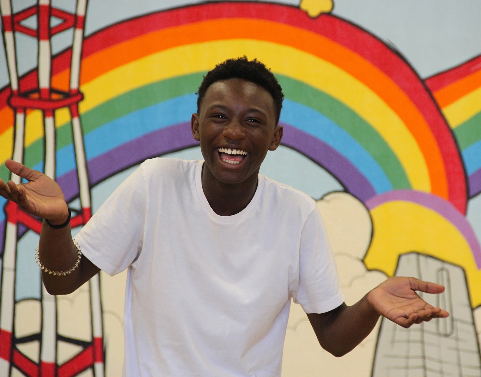 Smiling boy in front of a rainbow backdrop